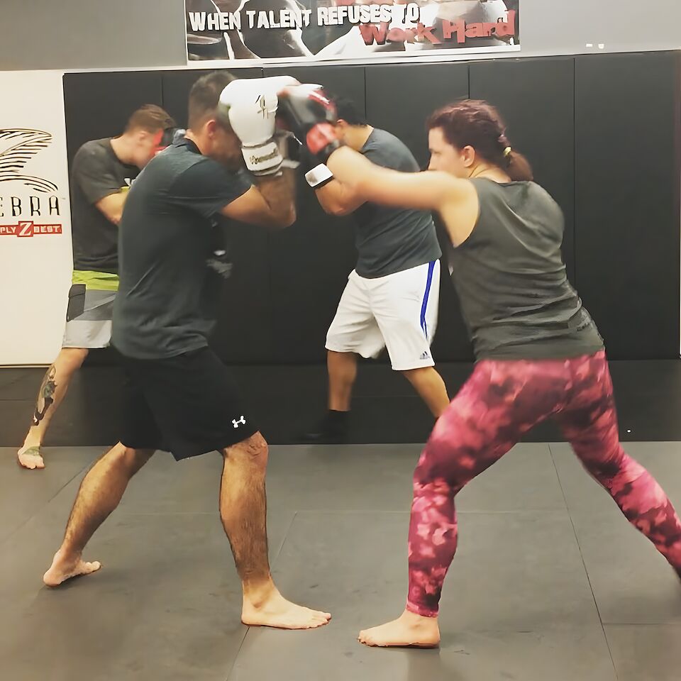 Two adults drilling boxing sparring on the mats at Rumble Martial Arts in Keswick.