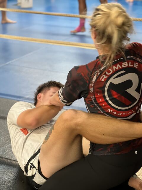 An adult student throwing pad combinations in the boxing ring at Rumble Martial Arts.