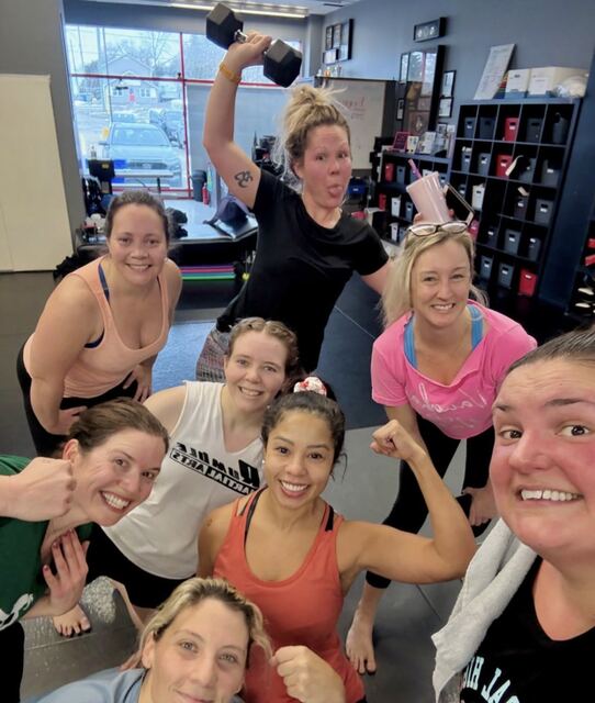 A Battle Girl Bootcamp group selfie after class, everyone smiling and flexing.