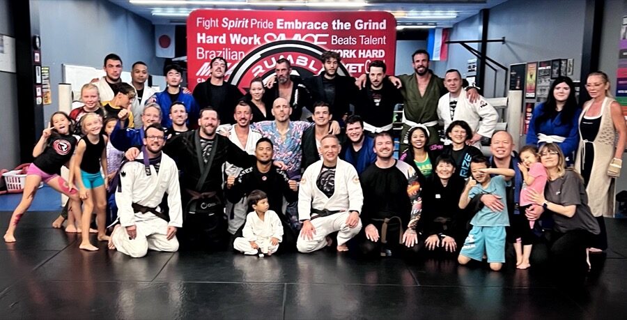 A group of Rumble BJJ students, including teens, together on the mats in gis