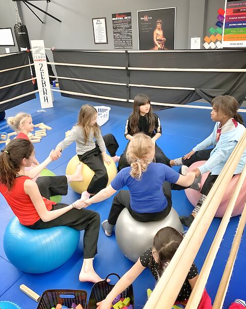 After-school kids in a circle on exercise balls at Rumble Martial Arts.