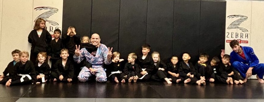 A kids class group photo on the mats at Rumble Martial Arts.