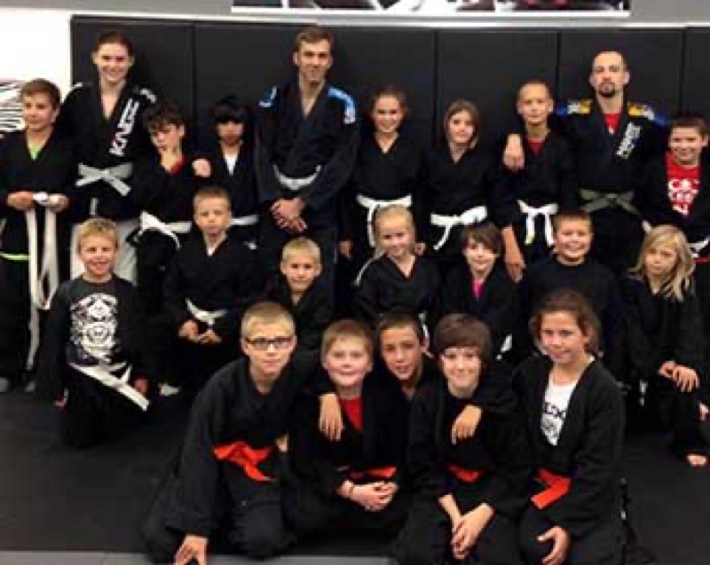 A group of Rumble students in black gis with various belt colours.