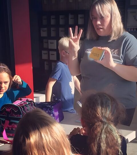 A Rumble staff member working through flashcards with after-school kids.